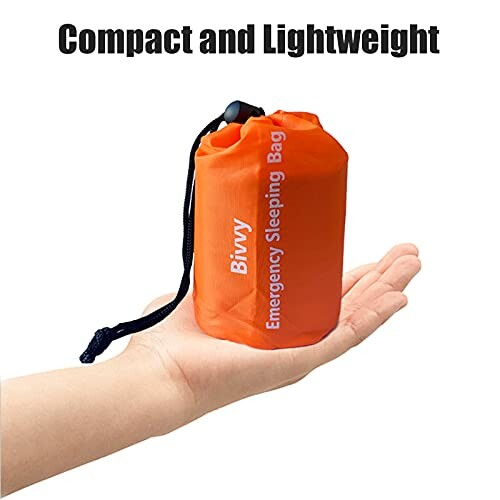 Compact and lightweight orange emergency sleeping bag in hand