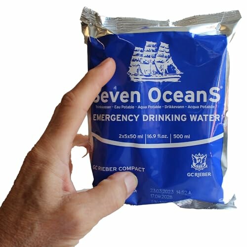 Hand holding a Seven Oceans emergency drinking water packet.