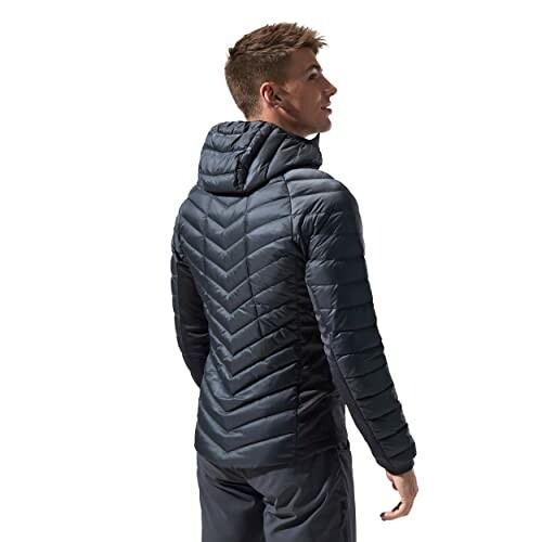 Man wearing a dark puffer jacket viewed from the back.